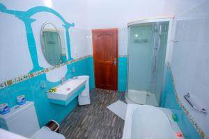 a blue bathroom with a toilet sink and a mirror at Villa Silent Harbour in Bentota