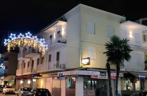 a white building with christmas lights in front of it at Lizard Residence in Lido di Jesolo