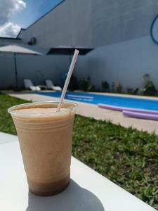 a drink in a plastic cup sitting on a table at Clima Termal Suites in Federación