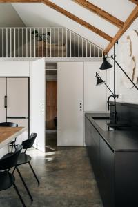 a kitchen with white cabinets and black counters at Wolny Las in Ławki