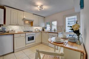 a kitchen with white cabinets and a wooden table at 2 Bed in Appledore oc-whimbc in Appledore