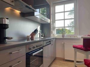 a kitchen with a stove top oven next to a window at Apartment Annika by Interhome in Hückeswagen