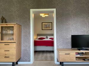 a bedroom with a bed and a tv and a mirror at Apartment Annika by Interhome in Hückeswagen