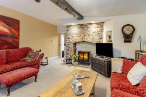 a living room with a stone fireplace and red couches at 3 Bed in Trellech oc-j34206 in Trelleck