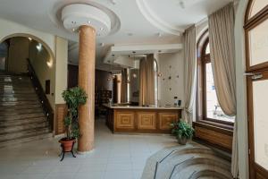 a lobby with a staircase and a column in a building at Hotel Beograd in Čačak