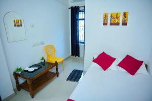 a bedroom with a bed and a table and a chair at Roomify Inn in Trivandrum