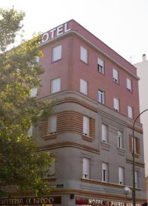 un gran edificio rojo con un cartel de hotel en Hotel 4C Puerta Europa, en Madrid