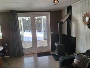 a living room with a wood stove and a door at Fritidshus Hammare Hagfors in Hagfors