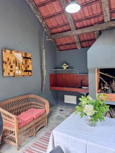 a living room with a wicker chair and a table at Casa do Til in Porto Moniz