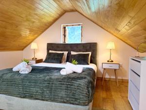 a bedroom with a large bed with two lamps at Casa do Til in Porto Moniz