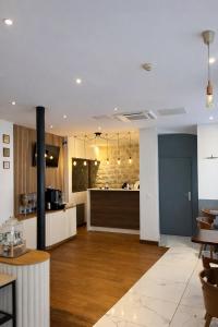 a room with a kitchen and a counter with chairs at Hôtel Tilde in Paris