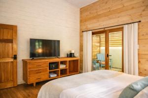a bedroom with a flat screen tv and a bed at La Casa Selva in Bocas Town