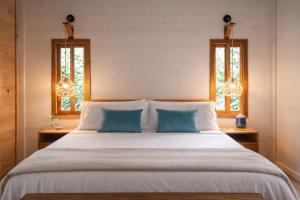 a bedroom with a large bed with two blue pillows at La Casa Selva in Bocas Town