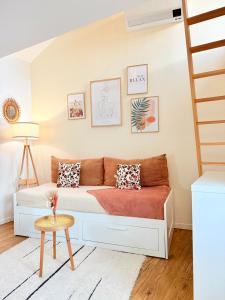 a living room with a couch and a staircase at La Chambrote - Maison, spa privatif & clim in Brive-la-Gaillarde