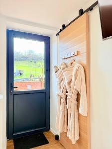 a door leading into a room with towels hanging at La Chambrote - Maison, spa privatif & clim in Brive-la-Gaillarde