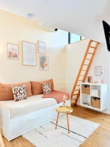a living room with a couch and a staircase at La Chambrote - Maison, spa privatif & clim in Brive-la-Gaillarde