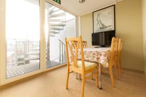 a dining room with a table and chairs and a balcony at Carolina Hotel in Pärnu