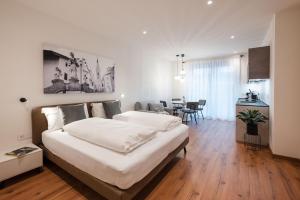 a bedroom with a large bed and a dining room at ecHo Apartments & SPA in Bressanone +148 photos