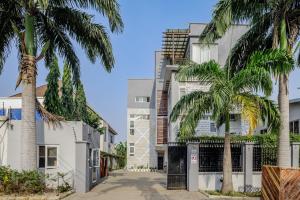 a building with palm trees in front of it at The Avery Apartments, Dzorwulu in Accra