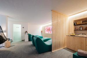 a living room with a row of blue chairs at ecHo Apartments & SPA in Bressanone