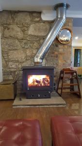 a fireplace in a living room with a stove at The Brander Lodge Hotel and Bistro in Taynuilt
