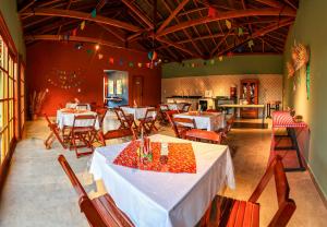 a restaurant with tables and chairs in a room at Pousada Charme da Mantiqueira in Passa Quatro