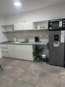 a kitchen with a sink and a refrigerator at Altos de Centro Chivilcoy 6 in Chivilcoy