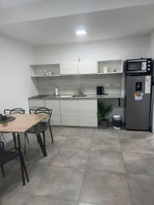 a kitchen with a table and a refrigerator at Altos de Centro Chivilcoy 6 in Chivilcoy