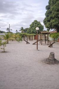 an empty park with wooden benches and trees at Lajedalu in Aquiraz