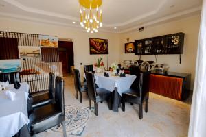 a dining room with a table and chairs and a chandelier at One Click Cozy Suites in Kigali