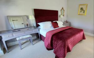 a bedroom with a bed and a dresser with a mirror at Rowsley Cottage Bakewell Peak District in Bakewell