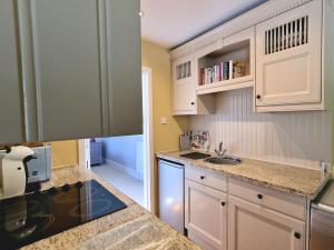 a kitchen with white cabinets and a sink at Rowsley Cottage Bakewell Peak District in Bakewell +9 photos