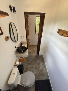 a bathroom with a white toilet and a sink at CASA NANDOS Studio quintal da mata !!! in Itacaré