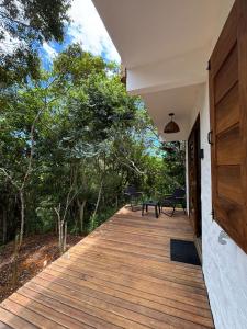 a wooden walkway leading to a house with trees at CASA NANDOS Studio quintal da mata !!! in Itacaré