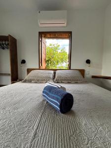 a bed with a blue bag on top of it at CASA NANDOS Flat Essência !!! in Itacaré