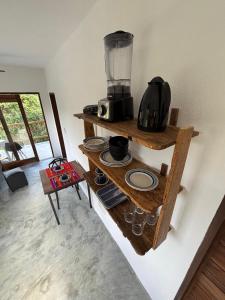 a kitchen with two wooden shelves and a blender at CASA NANDOS Flat Essência !!! in Itacaré