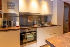 a kitchen with a sink and a stove at Les Lauzes 32-46 in Mussillon