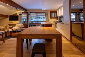a kitchen and dining room with a wooden table in a room at Les Lauzes 32-46 in Mussillon +7 photos