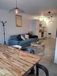 a living room with a blue couch and a table at VILLA Papillon , maison entière avec jardin in Champigny-sur-Marne