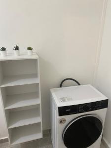 a microwave oven sitting next to a white shelf at Le Temps d une Escale in Trois-Rivières