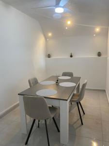 a dining room table with chairs and a ceiling fan at Le Temps d une Escale in Trois-Rivières