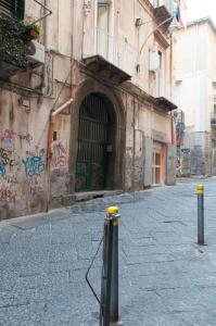 an empty street with a building with graffiti on it at Sfumature Partenopee in Naples