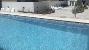 a large blue swimming pool with chairs at Oceano in Necochea