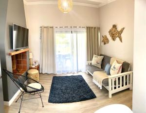a living room with a couch and a tv at Living Lite 1 and 2 in Kleinmond