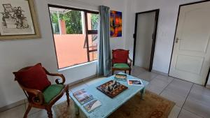 a living room with a table and chairs and a window at Harties Boathouse in Hartbeespoort