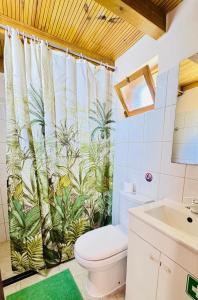 a bathroom with a toilet and a shower curtain at Casa do Til in Porto Moniz +36 photos