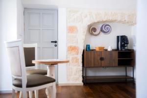 a table and a chair in a room with a door at Profumo Antico - Luxury Guesthouse by STHEY in Monopoli