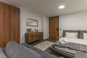 a bedroom with a bed and a couch at Beautiful Studio in Faqra in Kfardebian