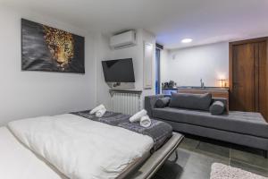 a bedroom with a bed and a couch and a television at Beautiful Studio in Faqra in Kfardebian