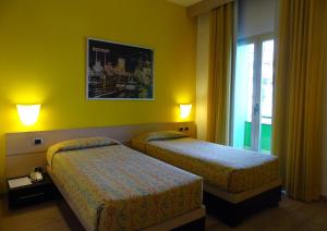 een hotelkamer met twee bedden en een raam bij Hotel I Cedri in Scandicci
